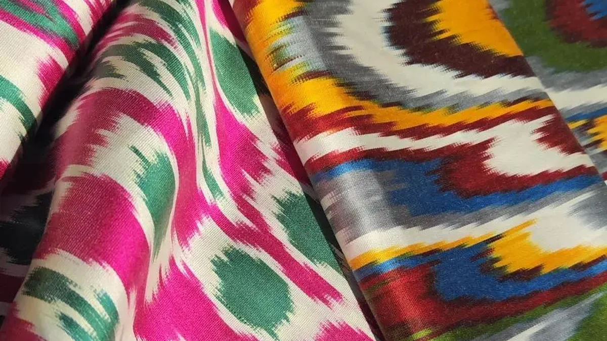 Drapierte Ikat-Seide in Pink, Ocker und Grün mit typisch weich auslaufenden Musterkanten